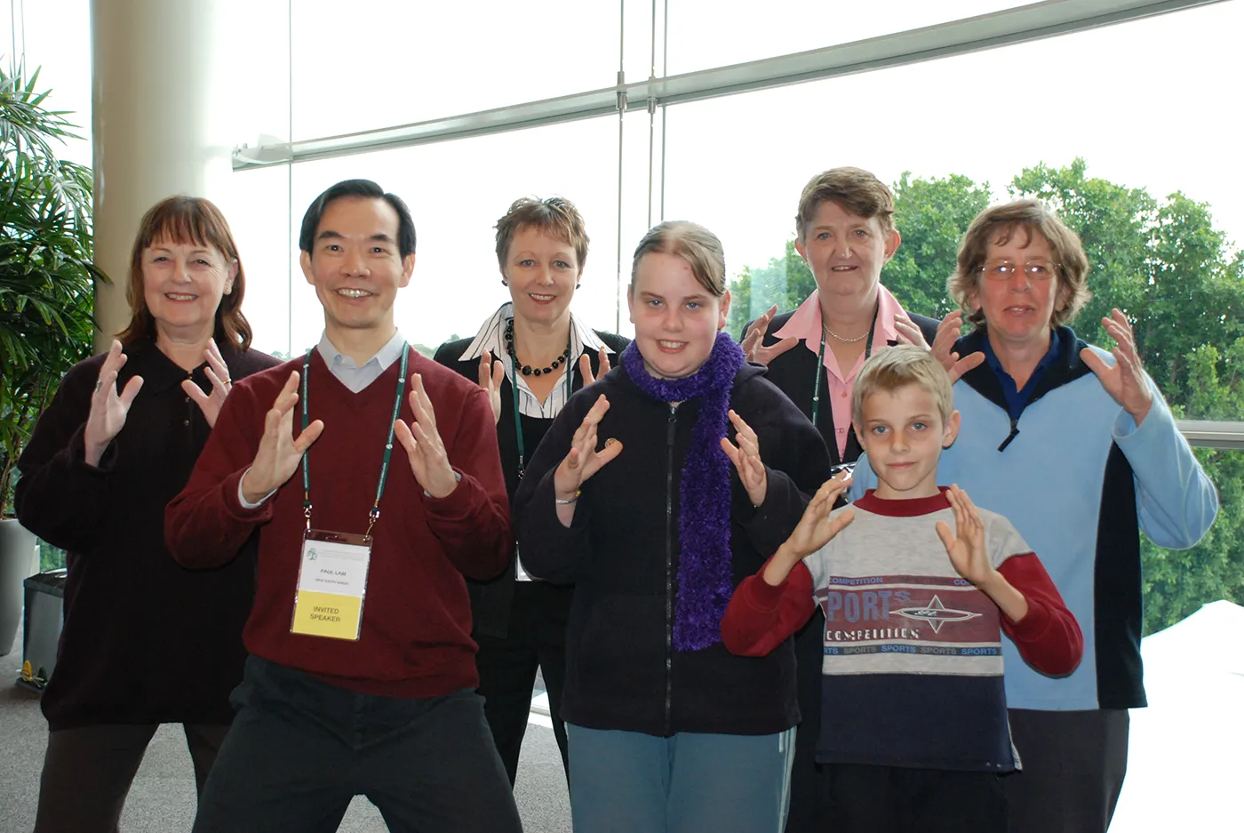 Dr Paul Lam with a group practising a tai chi movement at a health conference